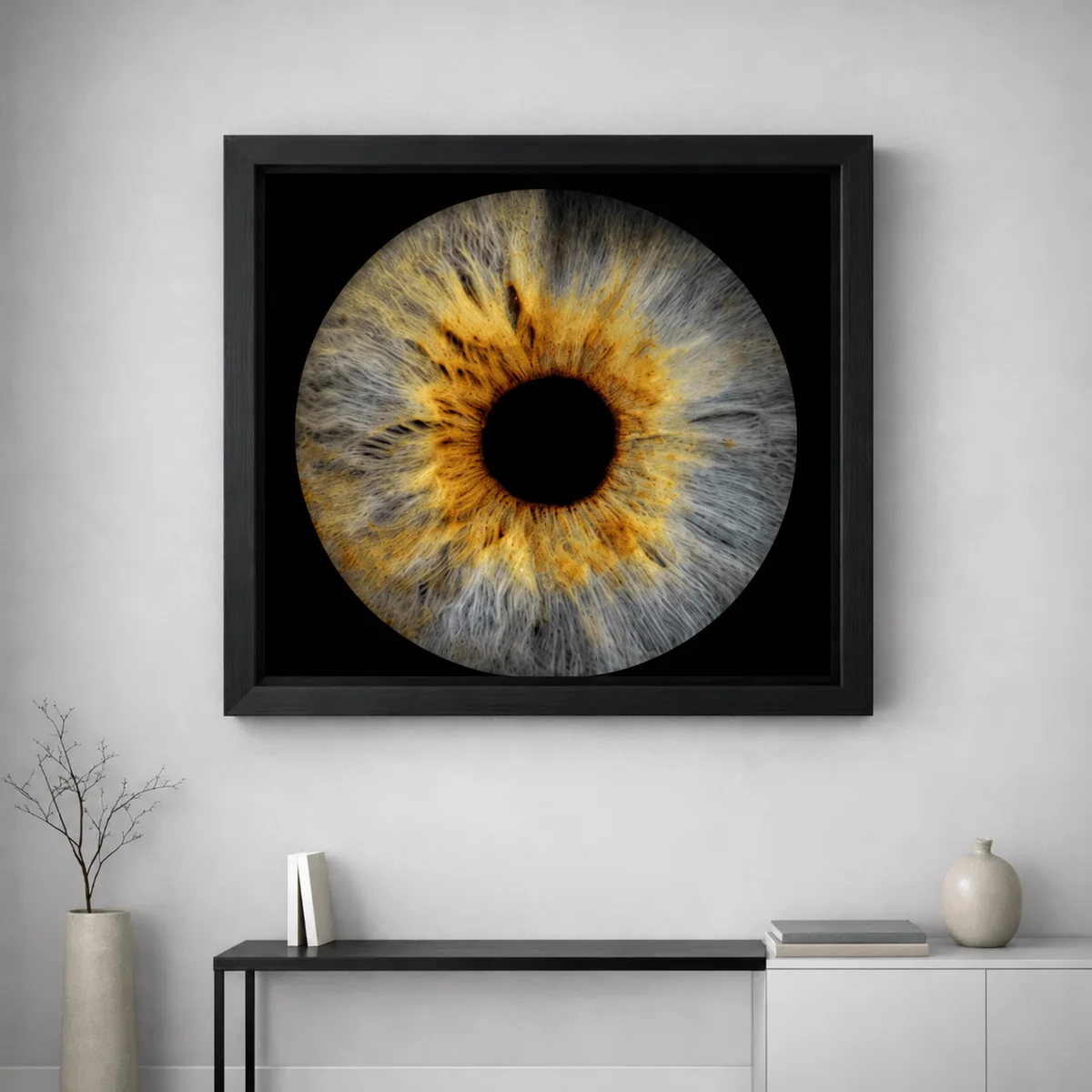 Golden and grey iris wall art in a black frame without a mount above a modern console